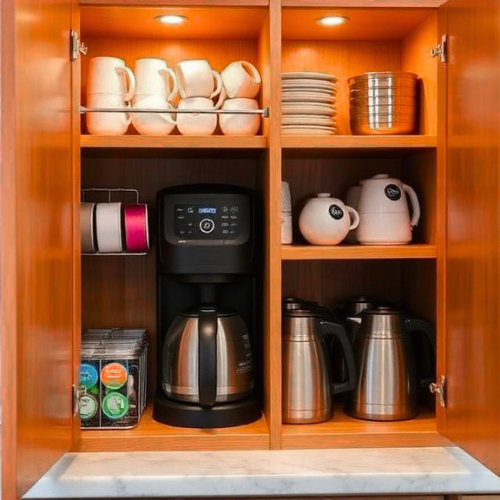 dedicated kitchen coffee cabinet with organized mugs, coffee pods in a holder, and a small lazy susan